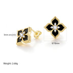 Product detail image of black four leaf clover stud earrings showing glossy acrylic petals, gold-tone settings, and size information.