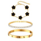 Three-piece gold tone bracelet set featuring black acrylic flower charms, a sparkling CZ tennis bracelet, and a stainless steel crystal bangle.