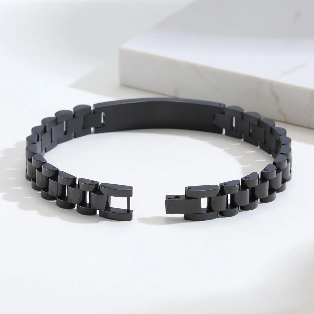Close-up of a black stainless steel medical ID link bracelet showing the curved ID plate and linked band.