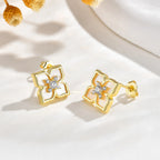 Pair of gold mother of pearl floral stud earrings displayed on a soft white surface with delicate yellow flowers.