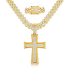 Gold tone iced out cross pendant necklace featuring sparkling rhinestones, a wide Cuban link chain, and a jeweled box clasp on a white background.