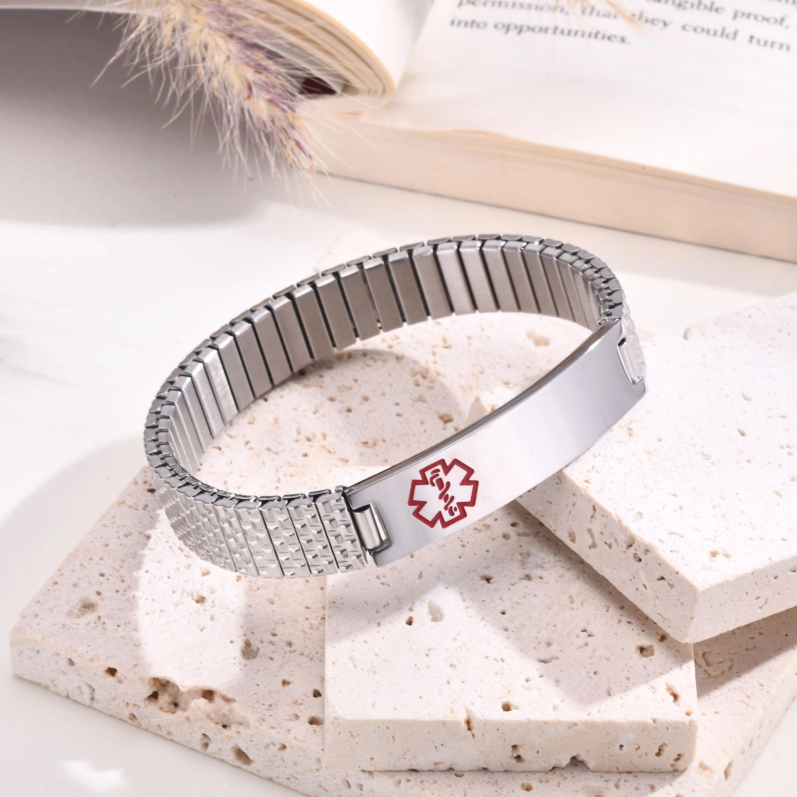 Silver medical ID stretch bracelet shown with a measuring tape to demonstrate adjustable wrist sizing.