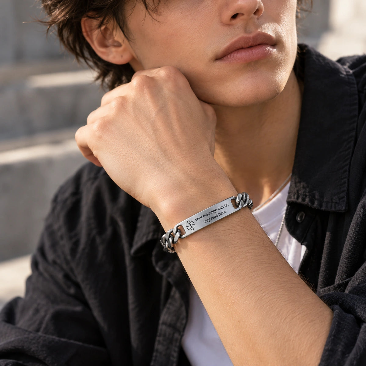 Man wearing a silver stainless steel medical ID curb chain bracelet on his wrist.