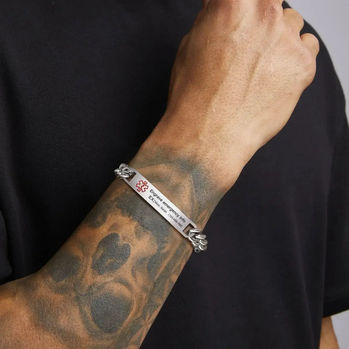 Man wearing a stainless steel medical ID curb chain bracelet with a polished silver ID plate

