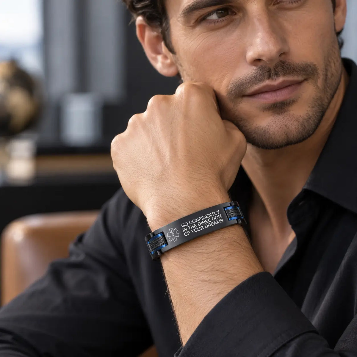 Man wearing a black and blue stainless steel link bracelet with a polished curved ID plate