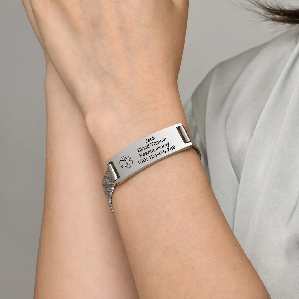 Person wearing a silver stainless steel medical ID mesh buckle bracelet on the wrist.