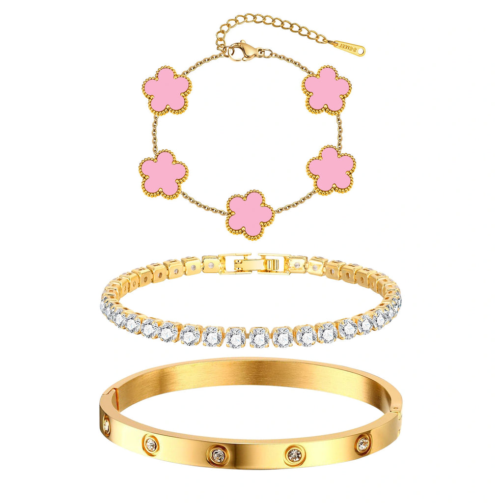 Three-piece gold tone bracelet set featuring five pink acrylic flower charms, a sparkling CZ tennis bracelet, and a stainless steel crystal bangle.