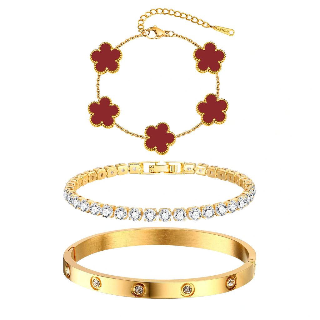 Three-piece gold tone bracelet set featuring five red acrylic flower charms, a sparkling CZ tennis bracelet, and a stainless steel crystal bangle.
