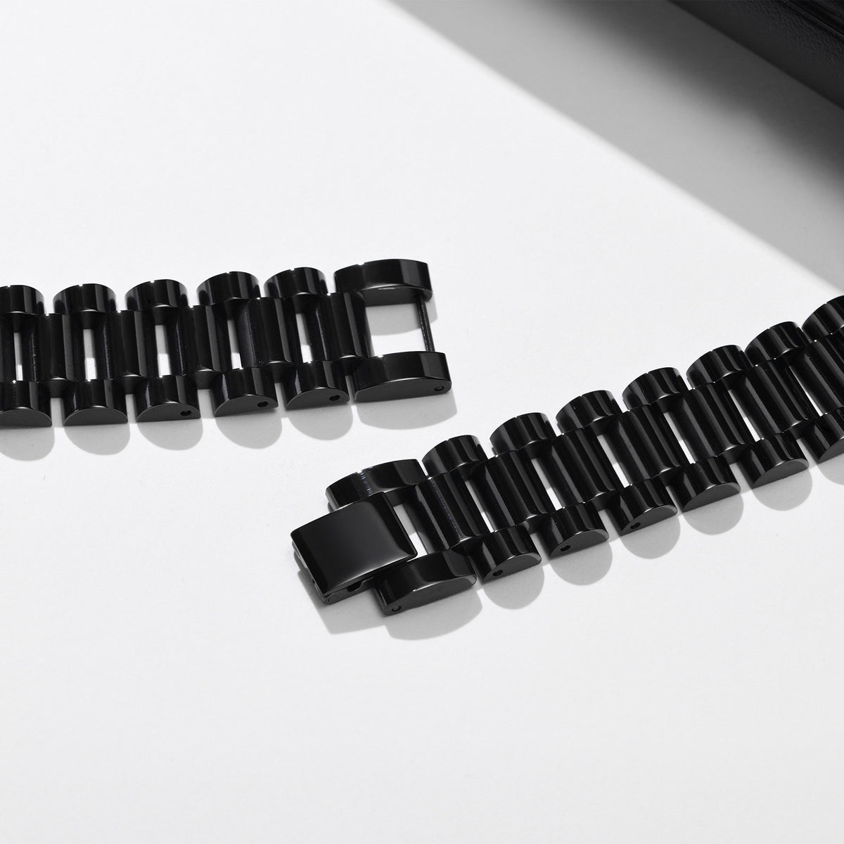 Close-up of removable black stainless steel bracelet links showing the chain construction and adjustable design