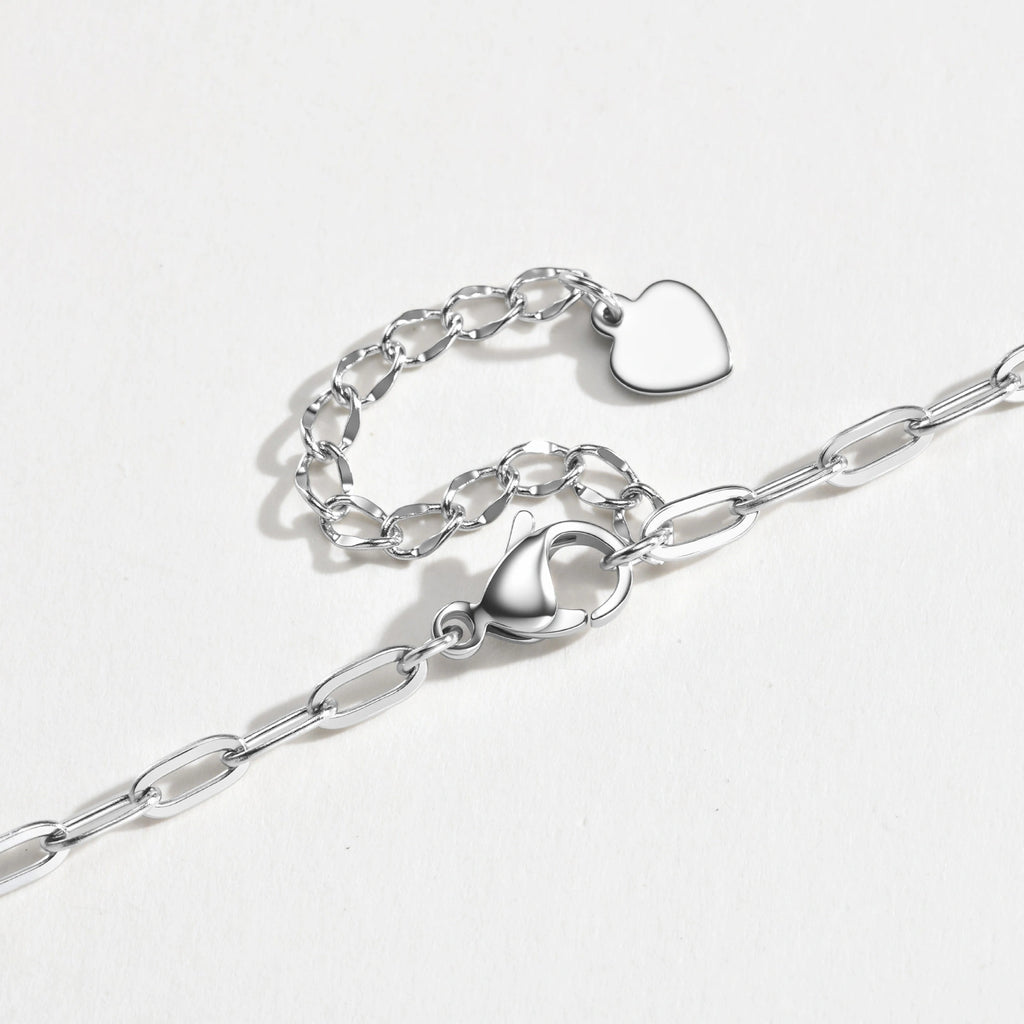 A silver paperclip chain necklace with a lobster clasp and a small heart-shaped charm, displayed on a clean white background.