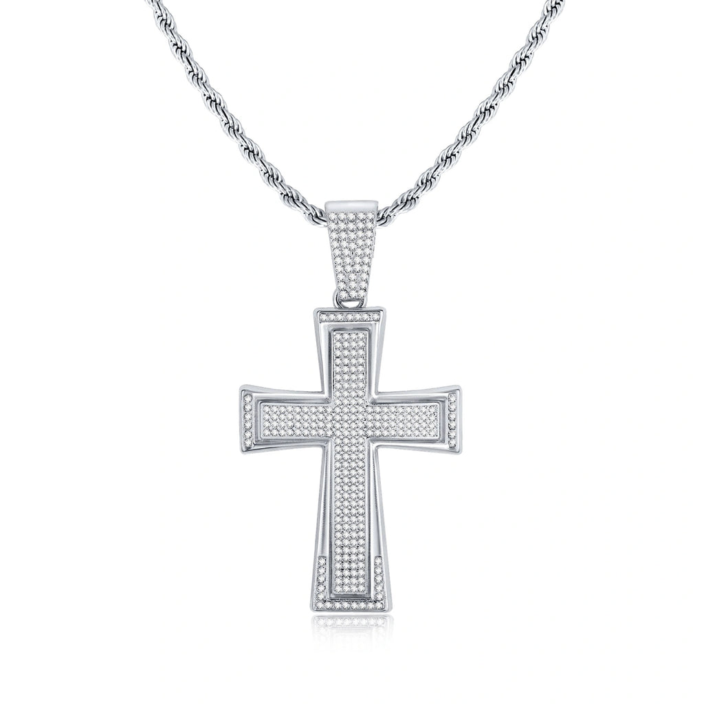 Silver tone iced out cross pendant necklace featuring sparkling rhinestones, a large cross design, and a textured rope chain on a white background.