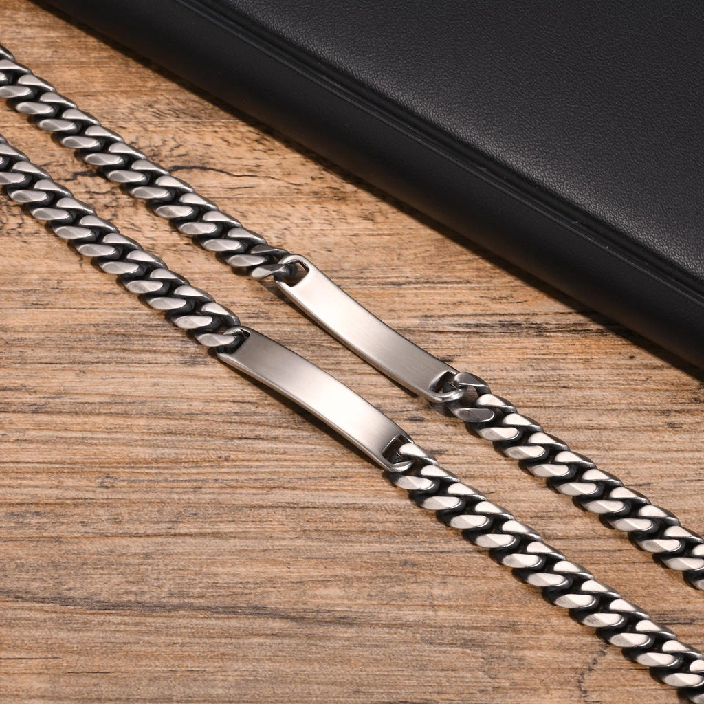 Close-up of a silver stainless steel ID bracelet showing the polished plate and chain links.