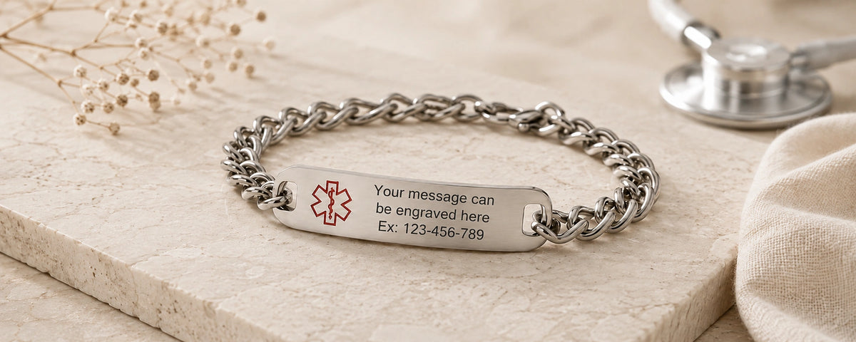 Personalized silver stainless steel medical ID chain bracelet with a polished engraved plate displayed on a light stone surface