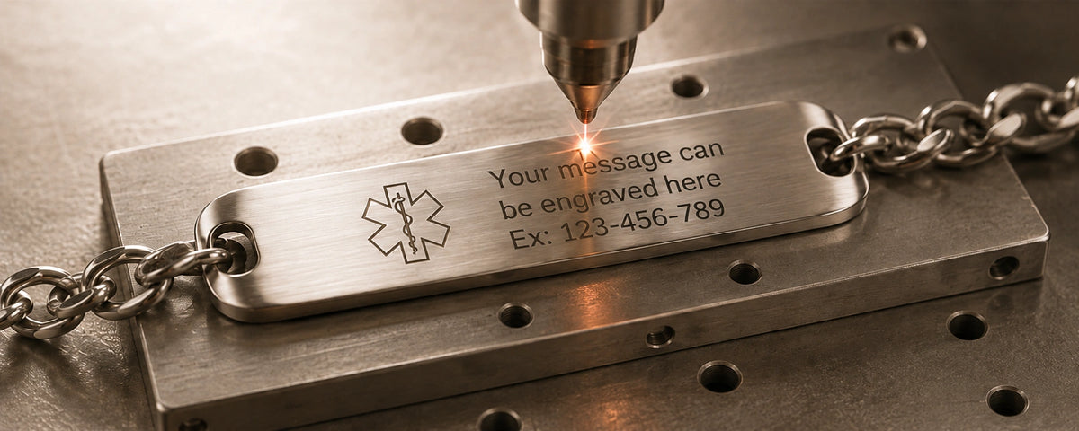 Close-up of laser engraving on a stainless steel ID bracelet plate, showing personalized text and a front emblem