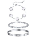 Three-piece silver tone bracelet set featuring five white mother of pearl flower charms, a sparkling CZ tennis bracelet, and a stainless steel crystal bangle.