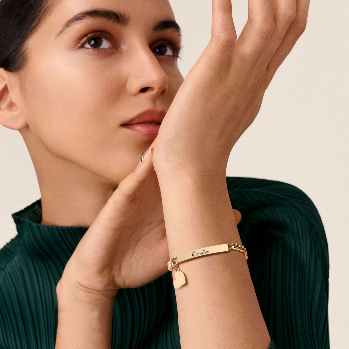 Woman wearing a gold personalized medical ID bracelet with curb chain and heart charm