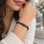 Woman wearing a black stainless steel medical ID chain bracelet on her wrist in an everyday setting.