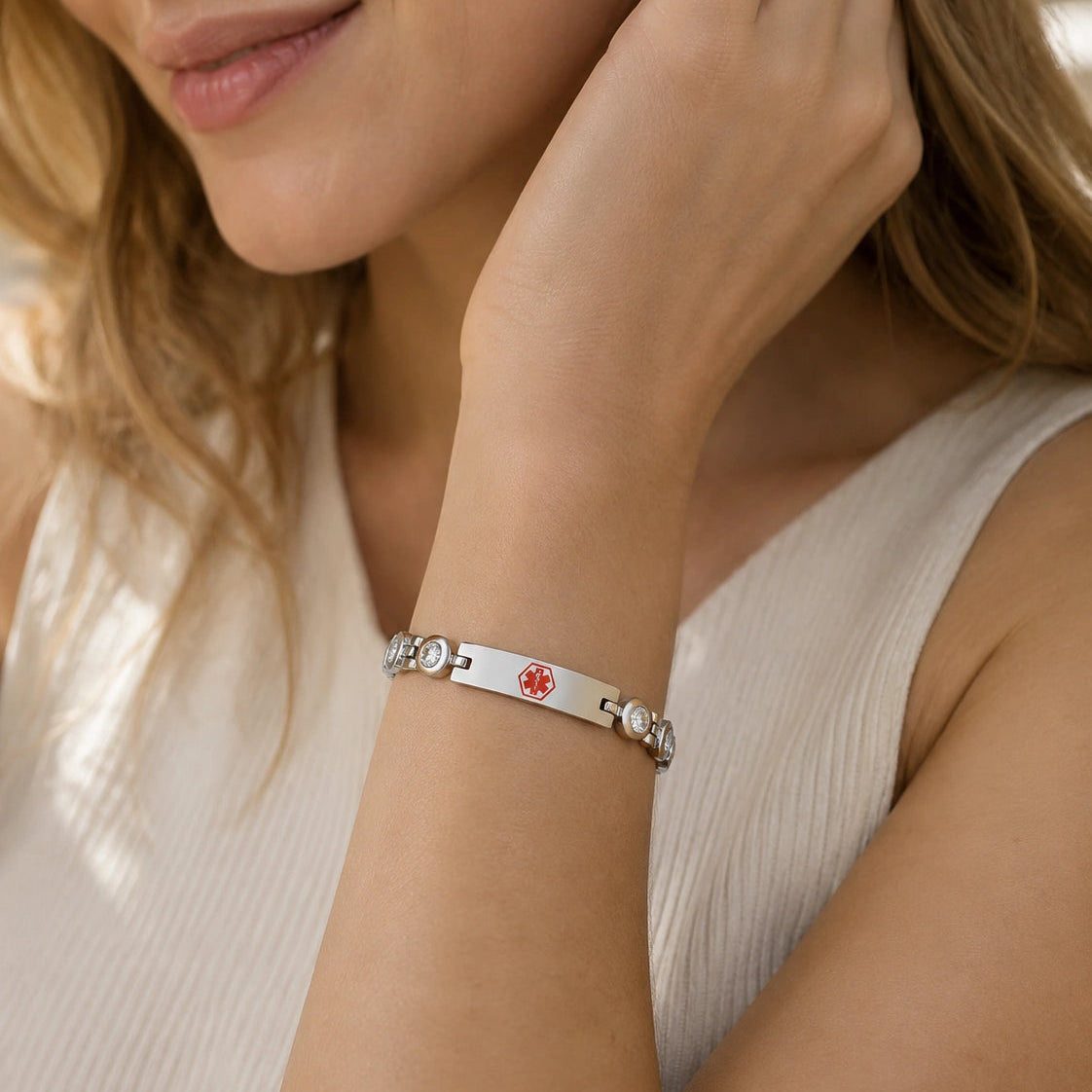 Woman wearing a silver medical ID bracelet with sparkling cubic zirconia accents on her wrist.